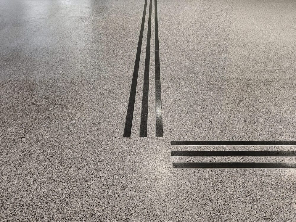 Svart aluminiumlist med halksäkert ilägg på ljust stengolv – leder fram till reeception.